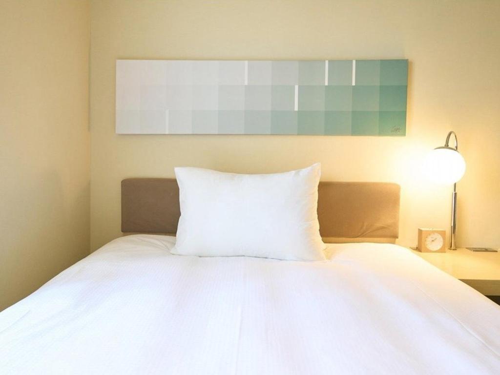 Postel nebo postele na pokoji v ubytování Hotel Resol Ikebukuro