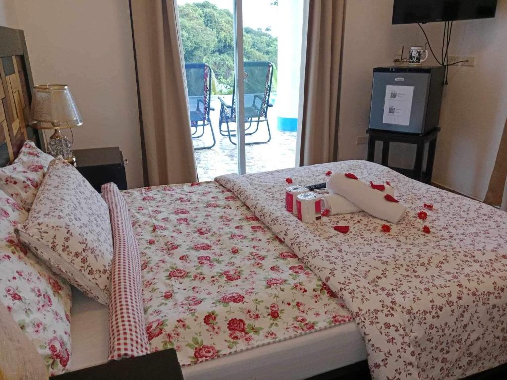 a bedroom with a bed with a blanket with roses at Couple room in Final Destination Resort in Bolinao