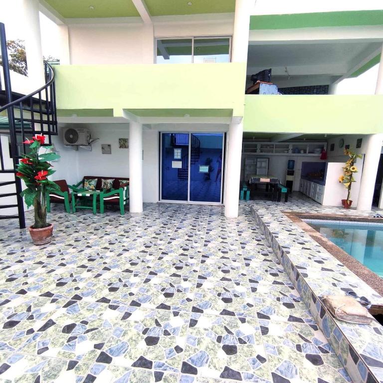 a house with a swimming pool and a blue door at Apartment in Holidays Beach Resort in Bolinao