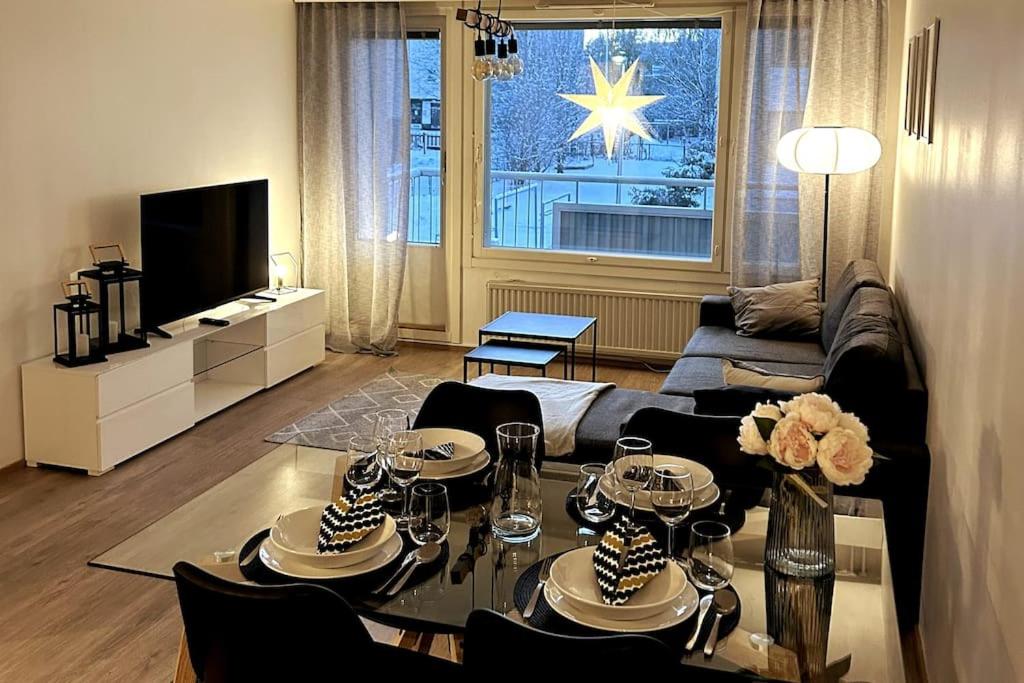 a living room with a couch and a table with chairs at Modern Apartment City Centre in Rovaniemi
