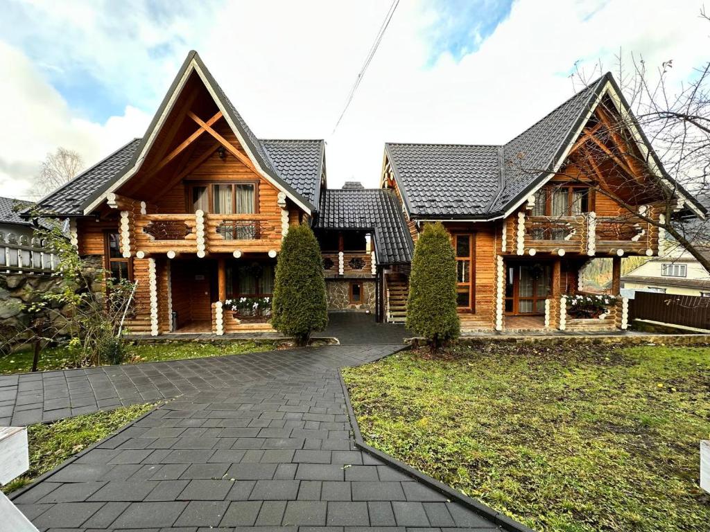 a large wooden house with a pathway in front of it at Oberig Apartmens in Vorokhta