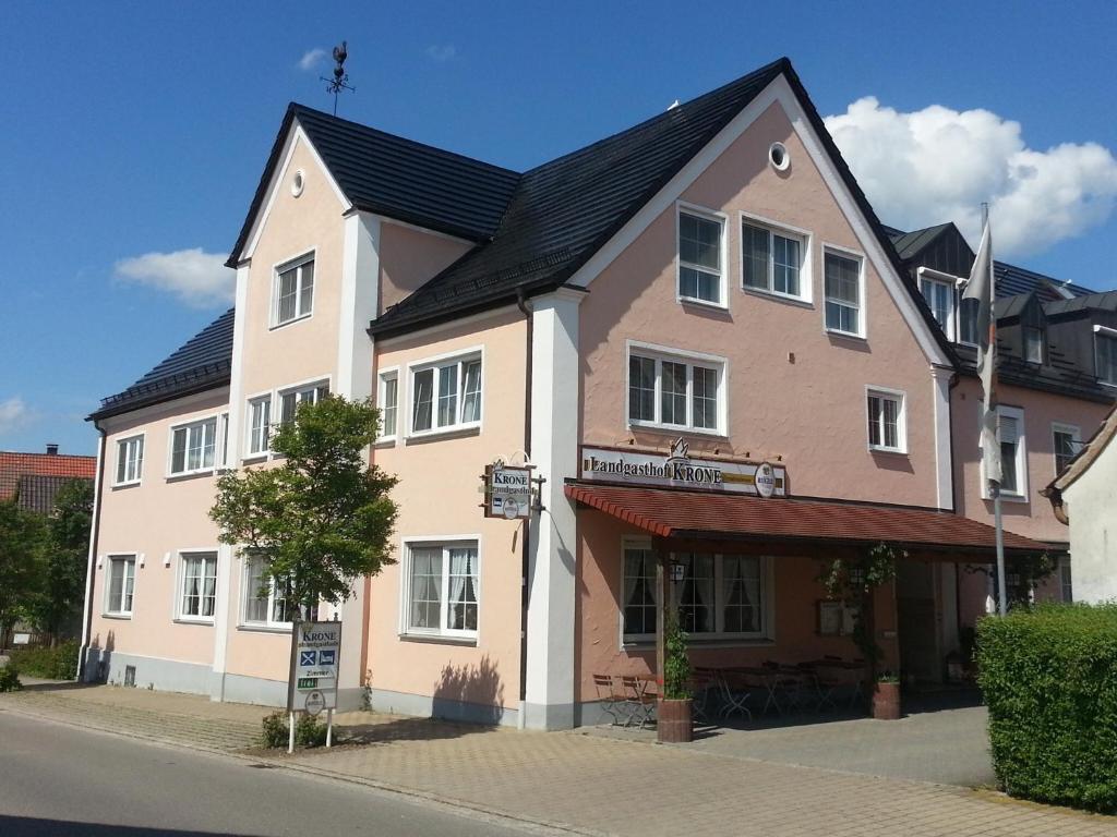 ein großes Haus mit schwarzem Dach auf einer Straße in der Unterkunft Landgasthof Krone in Offingen