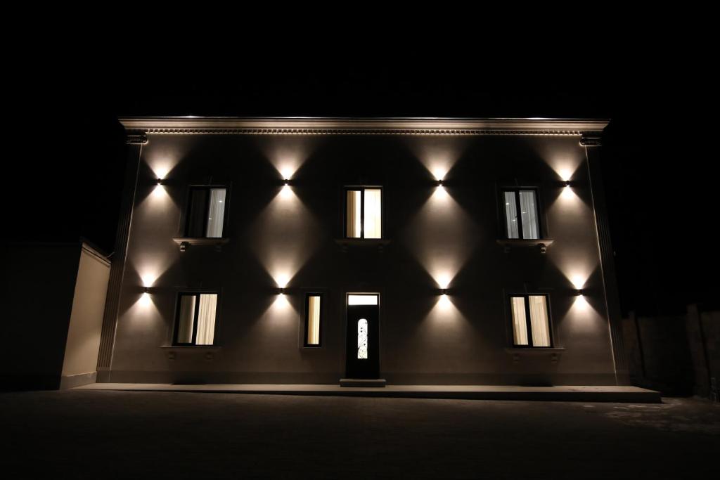 a building with lights on the front at night at LOUVRE HOME in Sevan