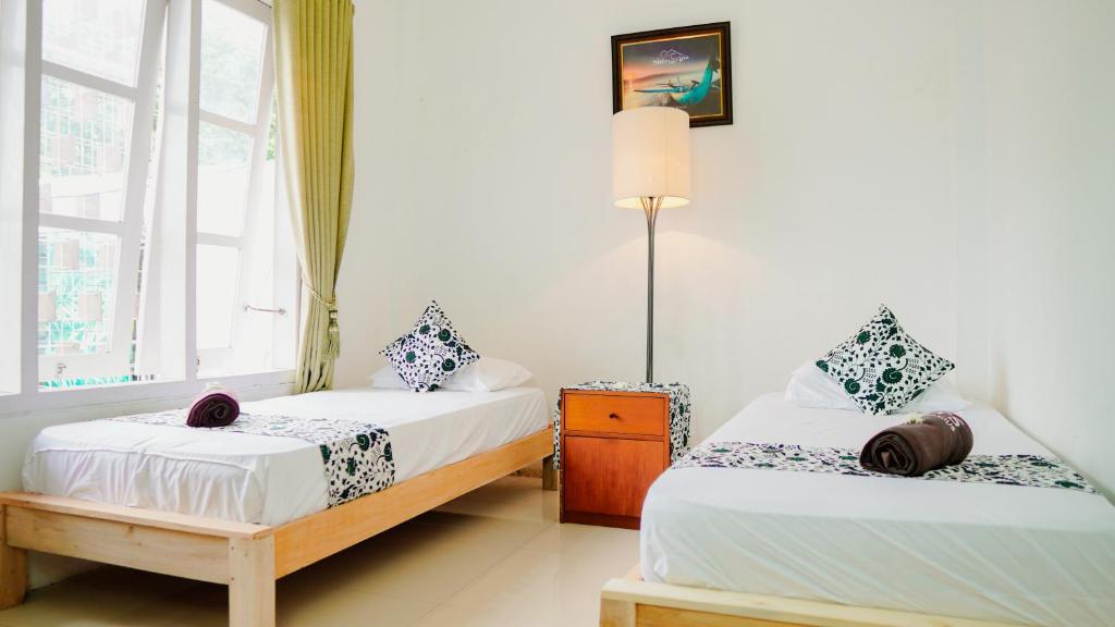 En eller flere senge i et værelse på Dormitory Tourism Sritanjung Banyuwangi with Ijen Tour By Celcius