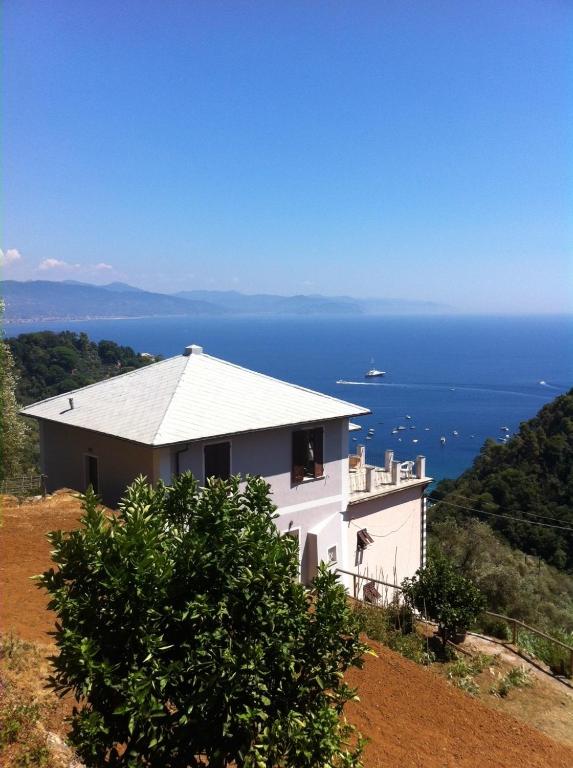 a white house on top of a hill with the ocean at Trekking in paradise B&B in Santa Margherita Ligure