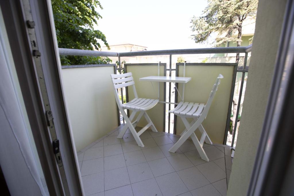 dwa krzesła i stół na balkonie w obiekcie Residence Eurogarden w Rimini