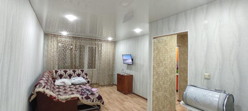 a room with a bed and a television in it at Квартиры Semey in Semey