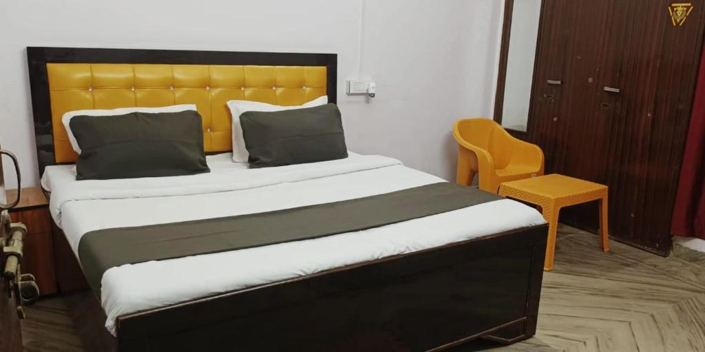a bedroom with a large bed with a yellow headboard at DBR GUEST HOUSE in Gorakhpur