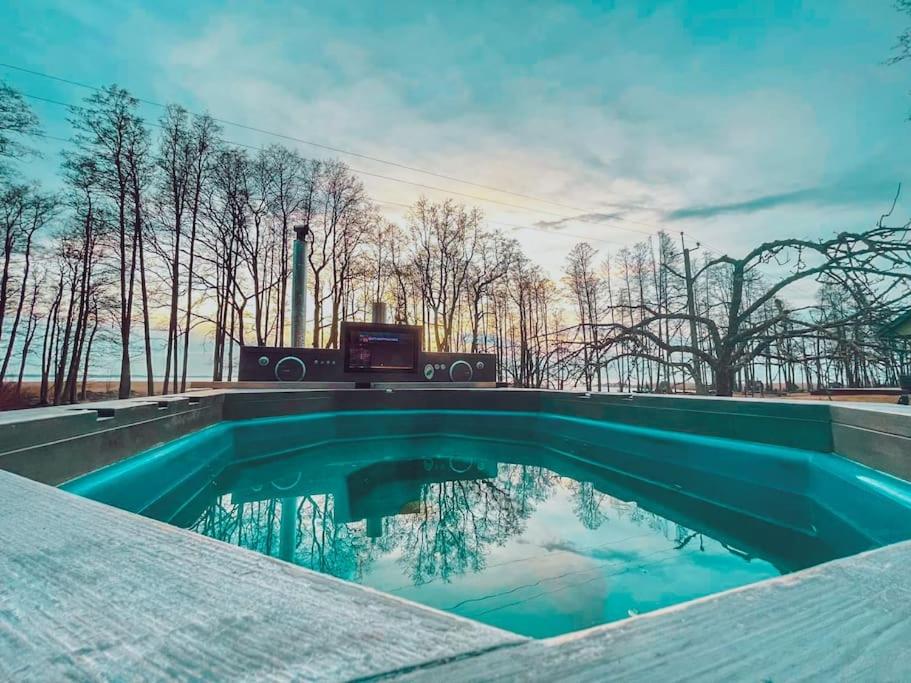 a swimming pool with a view of trees at Hide in the nature – cozy lakeside saunacottage in Rannaküla