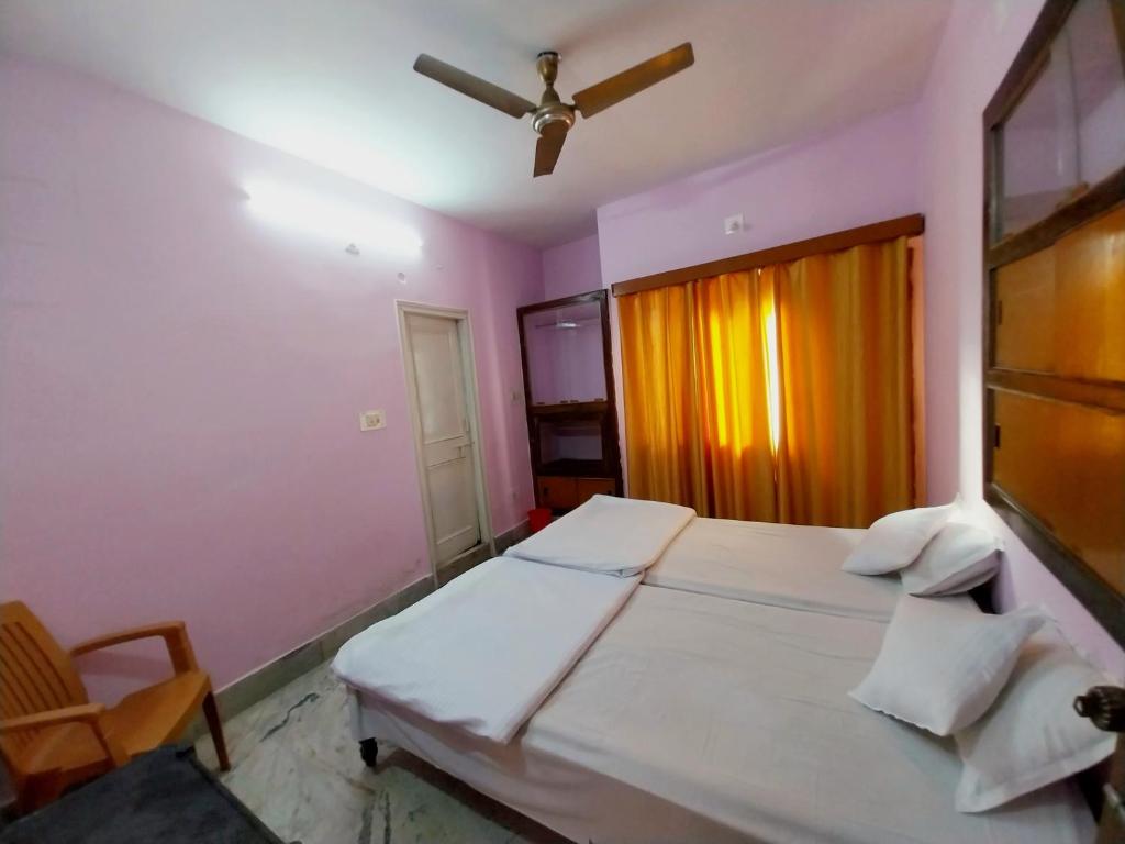 een slaapkamer met 2 bedden en een plafondventilator bij Aryan guest house in Bodh Gaya