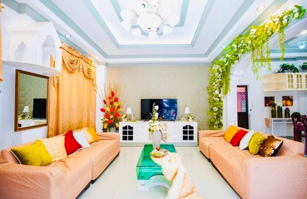 uma sala de estar com dois sofás e um gato sentado numa mesa em Spacious House in Talamban, Cebu City em Cebu