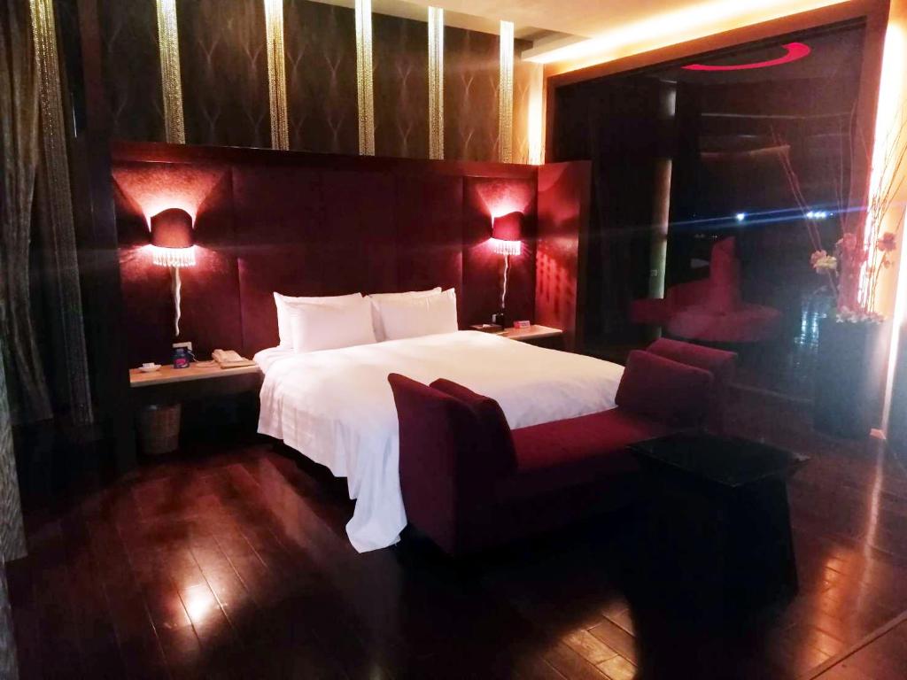 a bedroom with a large white bed and two lamps at Madrid Classic Hotel in Hsinchu City