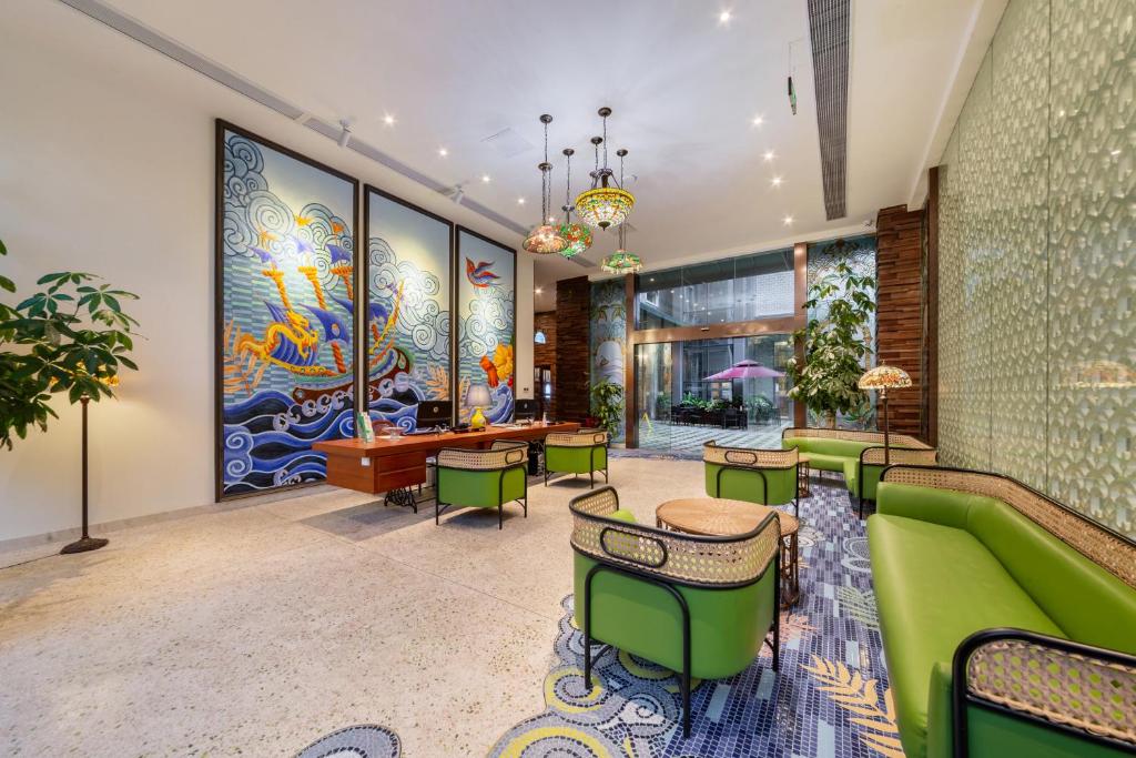 a lobby with a green couch and chairs at Overseas Chinese Town Nanyang Inn in Shenzhen