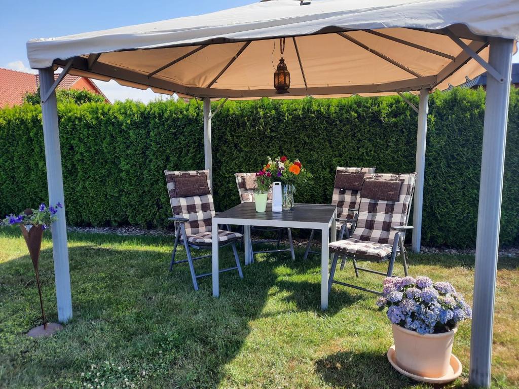 einen Tisch und Stühle unter einem Regenschirm im Hof in der Unterkunft Ferienwohnung "Safari" in Liepgarten