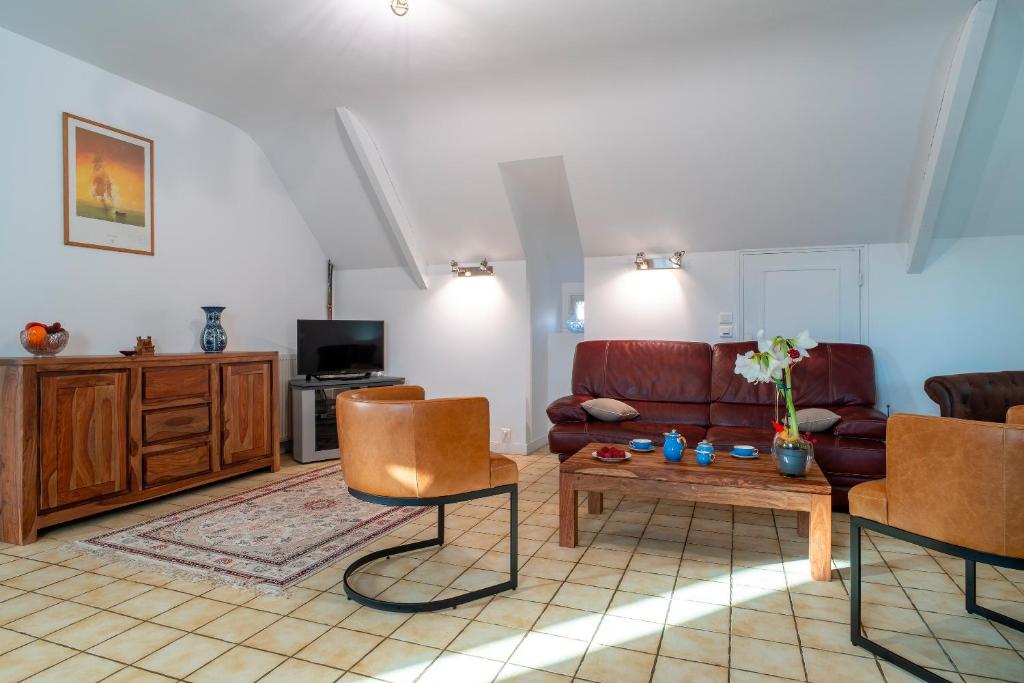 un salon avec un canapé et une table dans l'établissement Jacinthe - Appt dans une villa néo-bretonne, à Plomeur