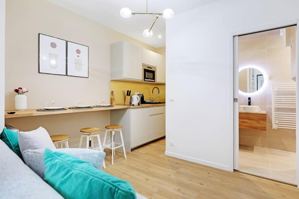 un salon avec un canapé et une cuisine dans l'établissement Charming Appartements for 4 people – Le Marais, à Paris
