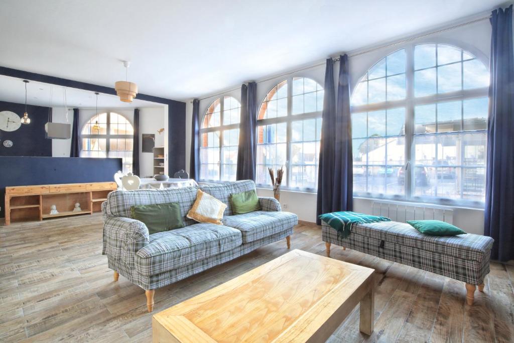 Una sala de estar con dos sofás y una mesa. en Les Sables D'or - Joli T3 200m de la plage, en Barneville-Carteret