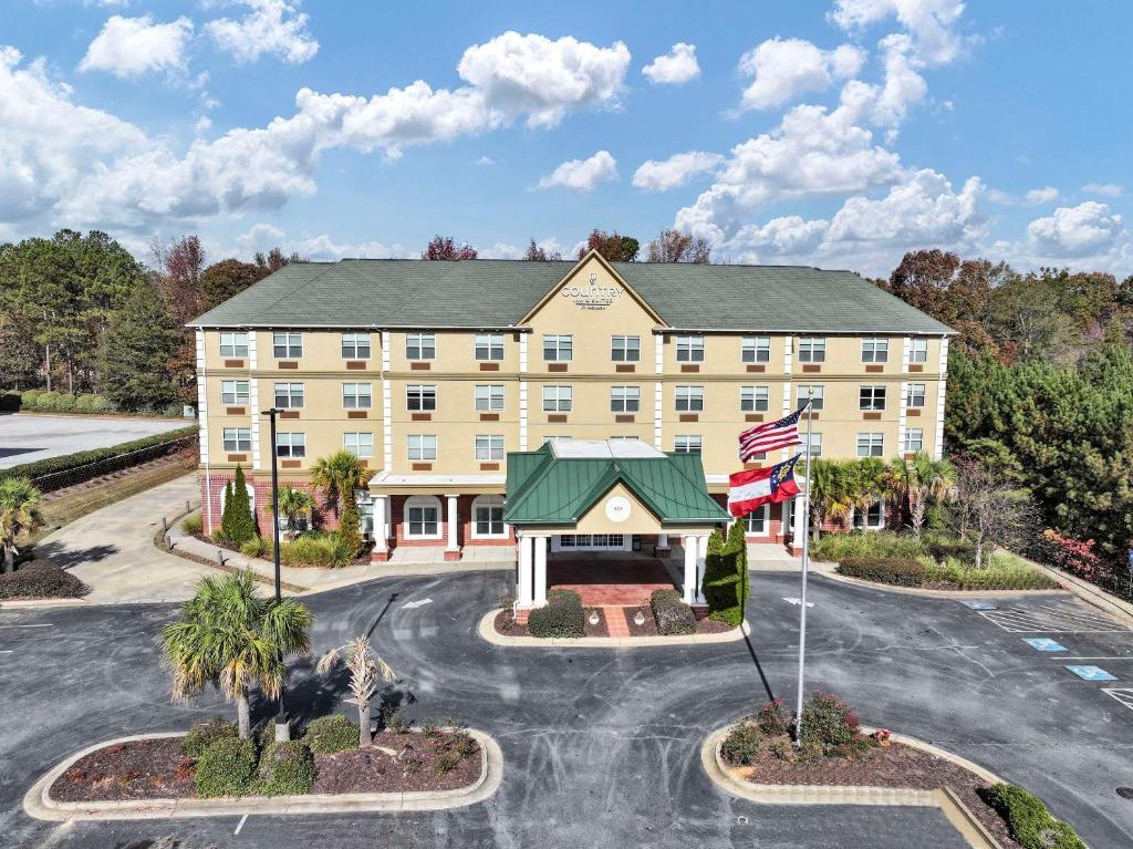 an exterior view of a hotel with a flag at Country Inn & Suites by Radisson, Braselton, GA in Braselton