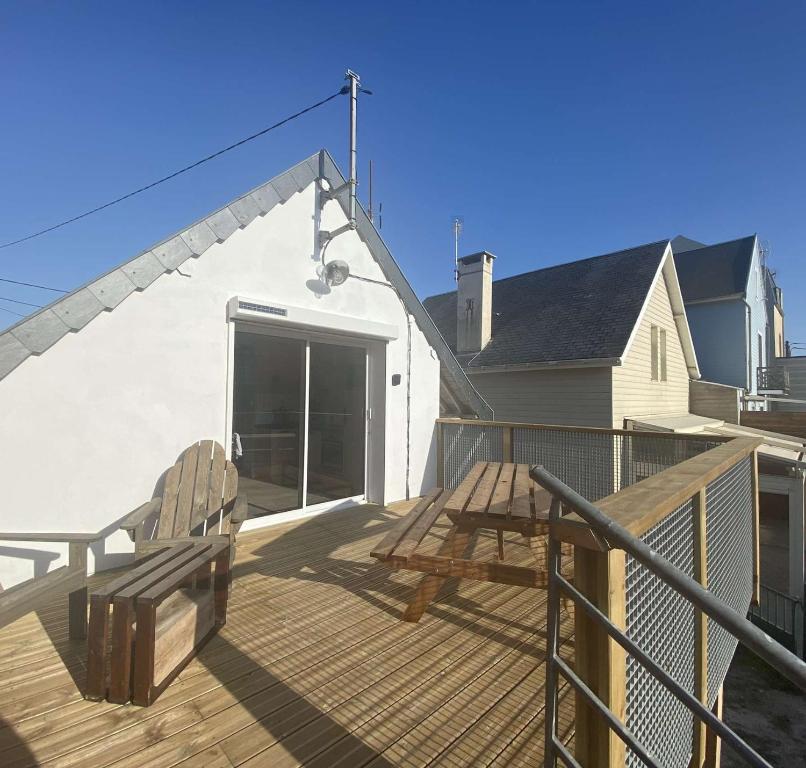 une terrasse en bois avec un banc et une table dans l'établissement EVASION, à Fort-Mahon-Plage