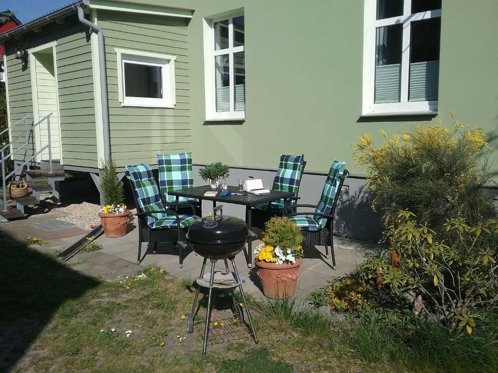 um pátio com uma mesa, cadeiras e comodidades para churrascos em Ferienhaus Emma Ferienwohnung "Paul" em Berndshof