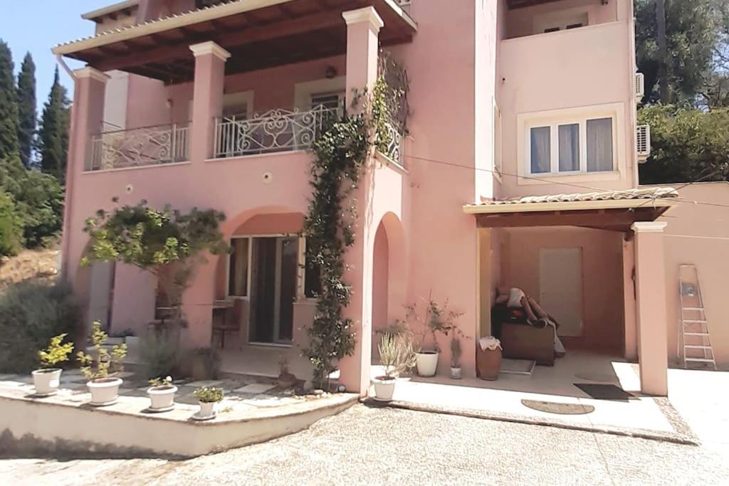 różowy dom z doniczkami przed nim w obiekcie villa olga-corfu w mieście Kynopiástai