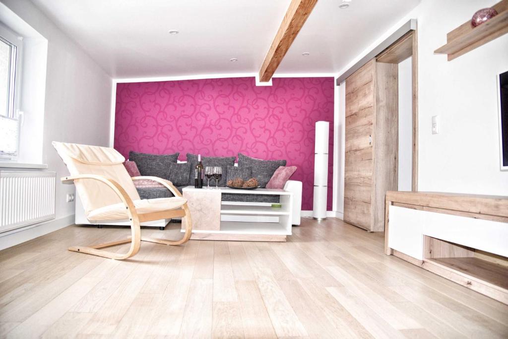 a living room with a pink accent wall at Ferienwohnung "Küstenliebe" in Neuendorf