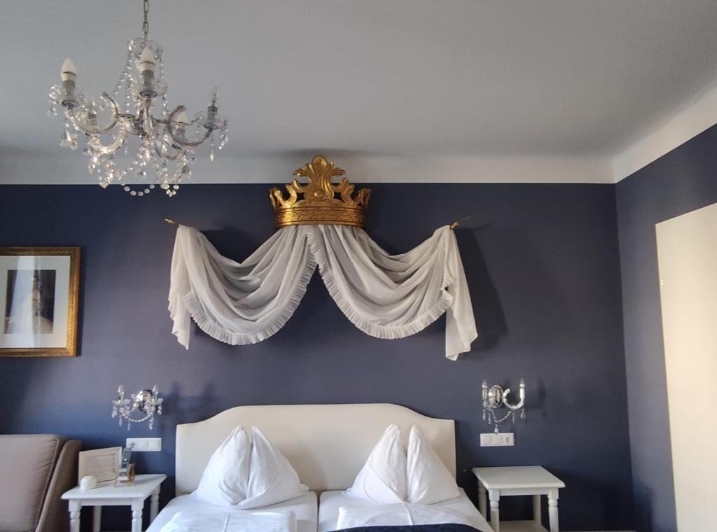 een slaapkamer met een bed met een kroon op de muur bij Marius Kammer und Koppel Engelbrecht in Höbersdorf