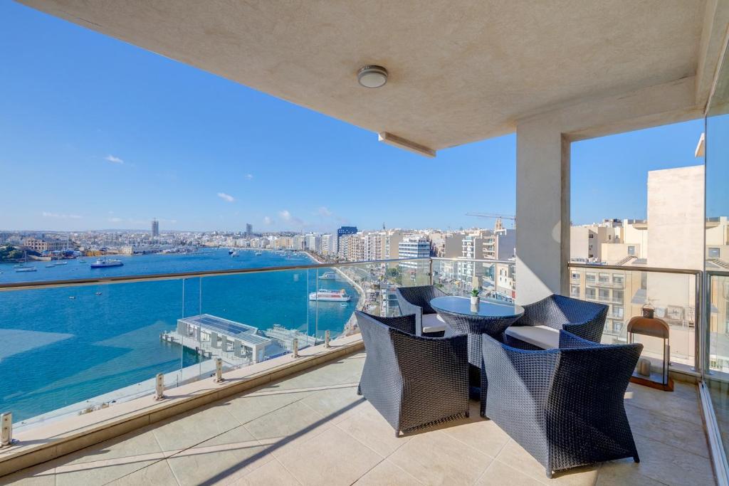 balcón con mesa, sillas y vistas a la ciudad en Valletta Skyline Serenity Luxury Harbour Views, en Sliema