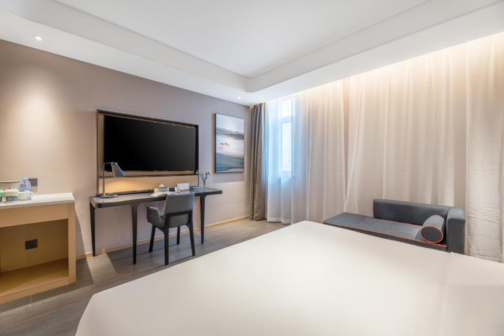 a hotel room with a bed and a desk at Atour Hotel Xi'an Chanba Exhibition Center Expo Park in Xi'an