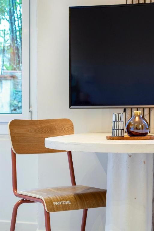 une télévision assise sur une table avec une chaise dans l'établissement Place Vauban, à Marseille