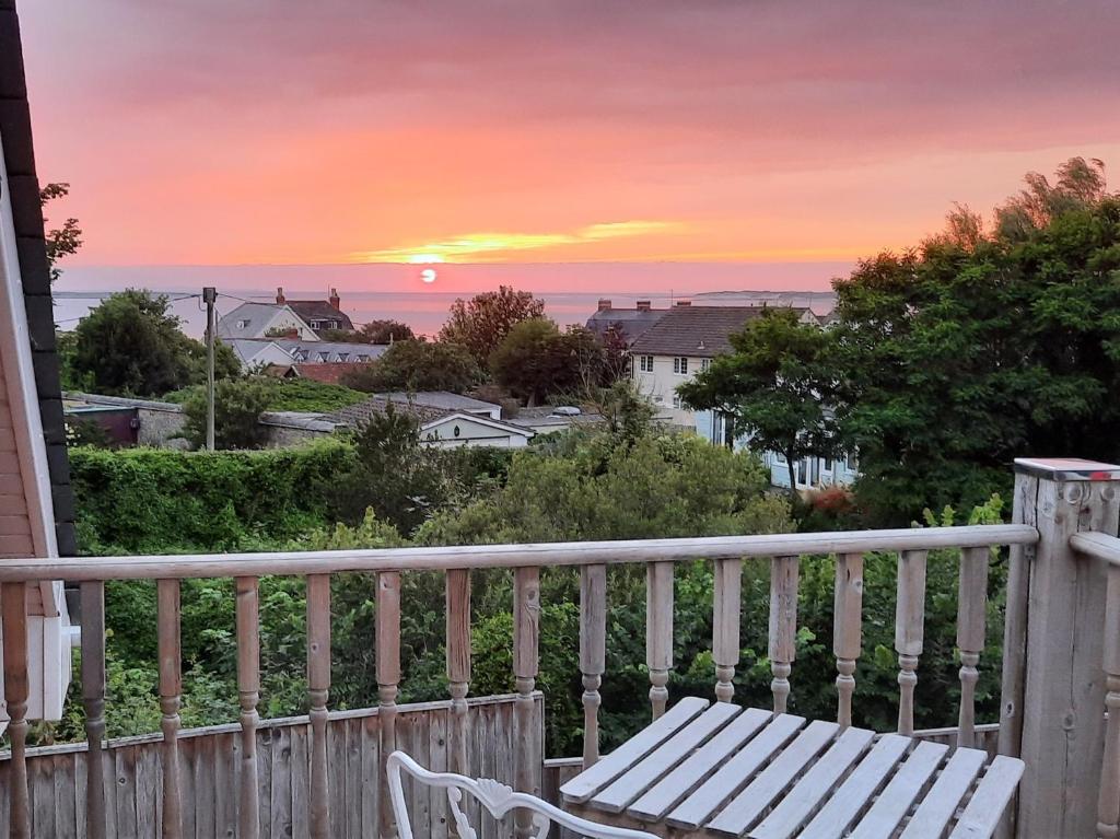 a bench sitting on a porch watching the sunset at 1 bed property in Instow 55340 in Instow