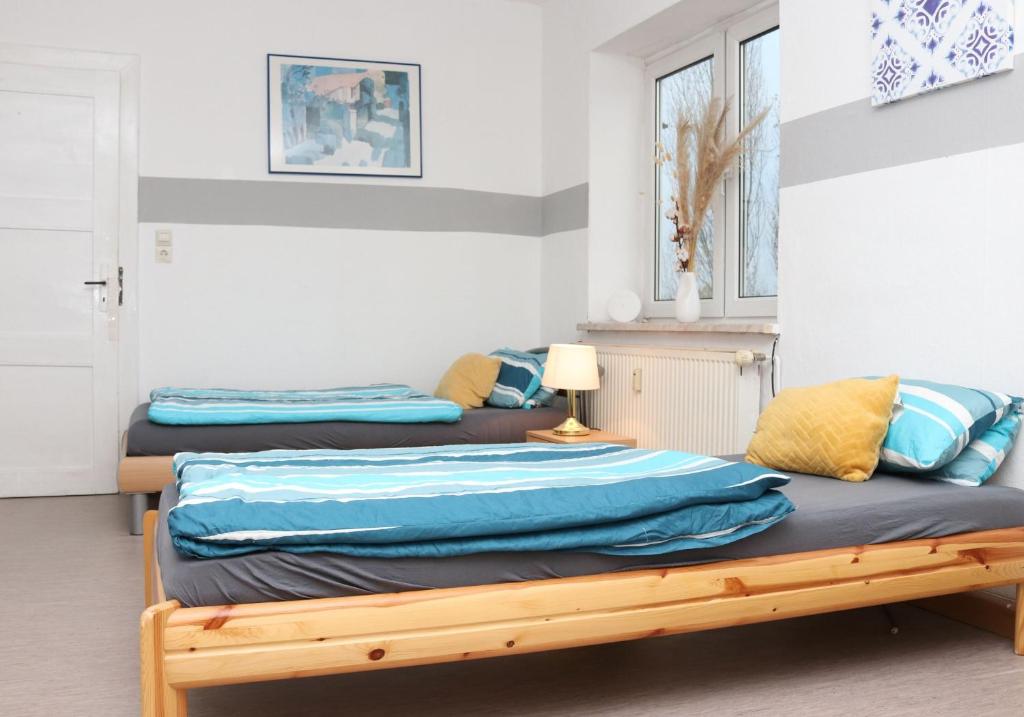 a bedroom with two beds with blue sheets at Rentarooms A in Oebisfelde