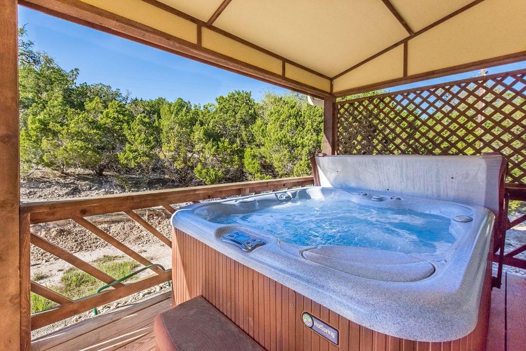 bañera de hidromasaje en el balcón con vistas en Appian Way Tuscan Cottage, en Fredericksburg