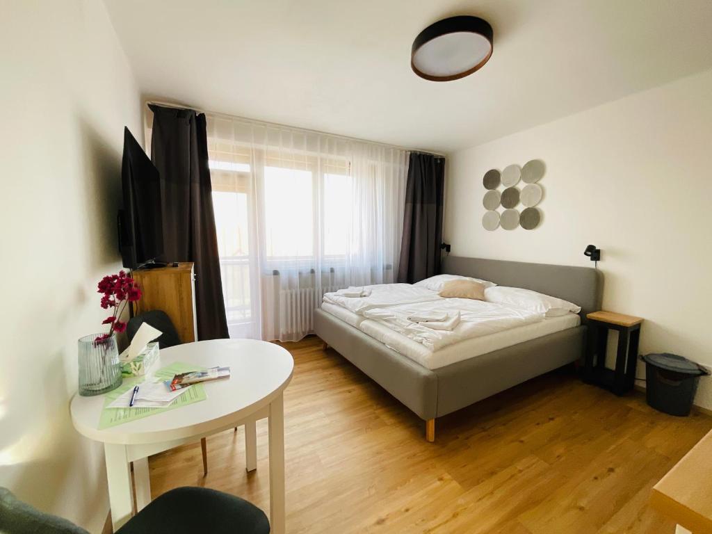 ein Schlafzimmer mit einem Bett und einem Tisch darin in der Unterkunft Apartmán č.4 v bankovním domě in Kutná Hora