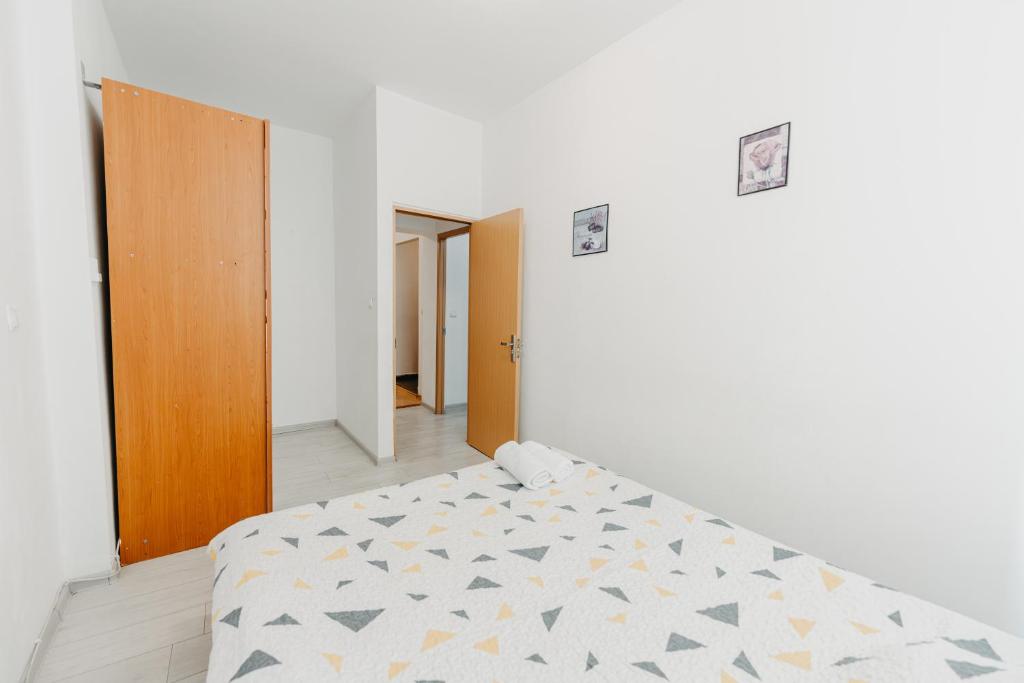 een slaapkamer met een bed in een witte kamer bij Apartament Piata Amzei 1 (17 B) in Boekarest