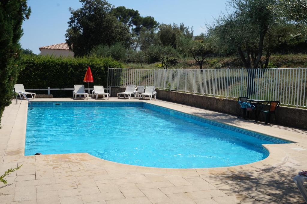 une petite piscine avec des chaises et une clôture dans l'établissement Logis Hotel Le Col De L'ange, à Draguignan