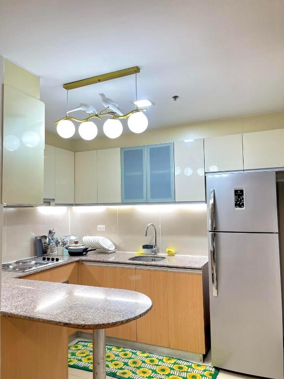 a kitchen with a white refrigerator and a sink at Mactan Newtown Rental by EJB in Punta Engaño
