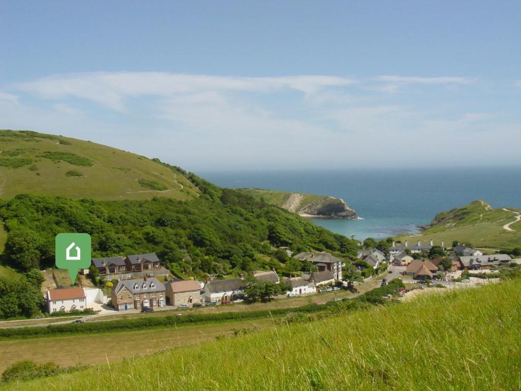 a small town on a hill with the ocean at 4 bed in Lulworth CHRIC in West Lulworth