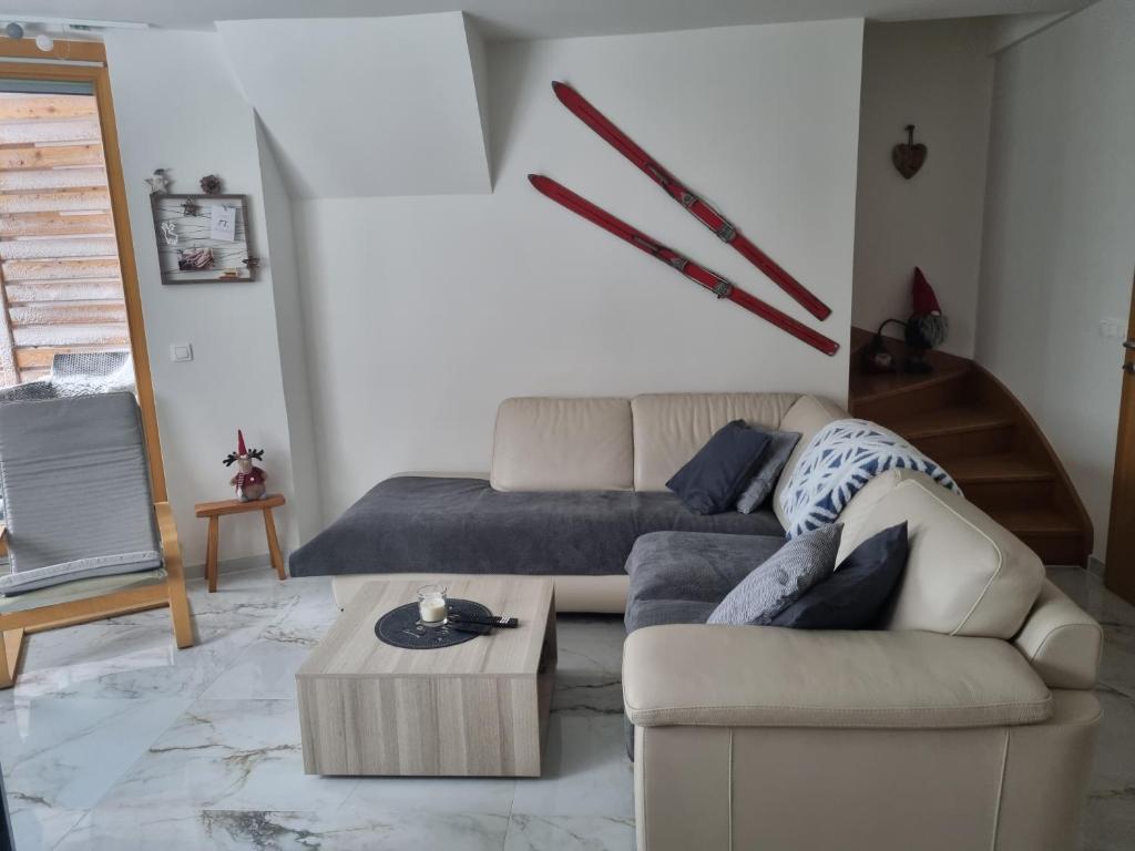 a living room with a couch and a coffee table at Forest View, 2-floor Apartment in Pohorje