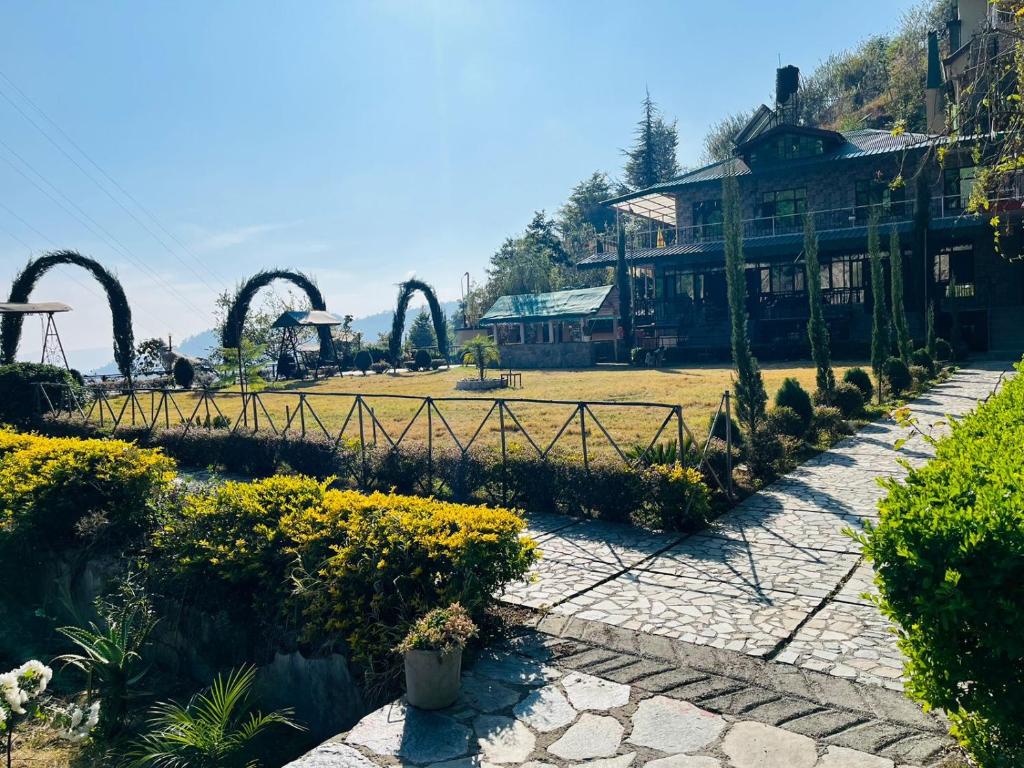 a garden with a park with a roller coaster at Green Lodge Farmstay by Highland Monk in Shimla