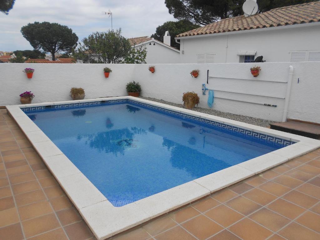 a swimming pool in a backyard with a white fence at Falguera in L'Escala
