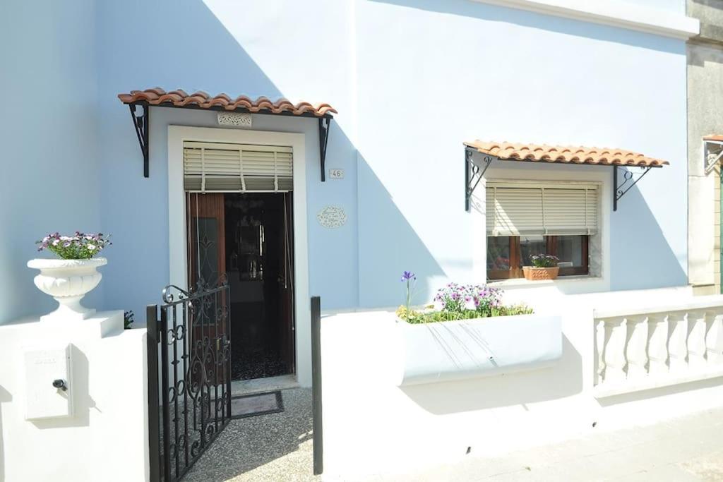 une maison bleue avec un portail noir et une porte dans l'établissement Appartamento Zii Mpeu by Salentoaffitti, à Racale