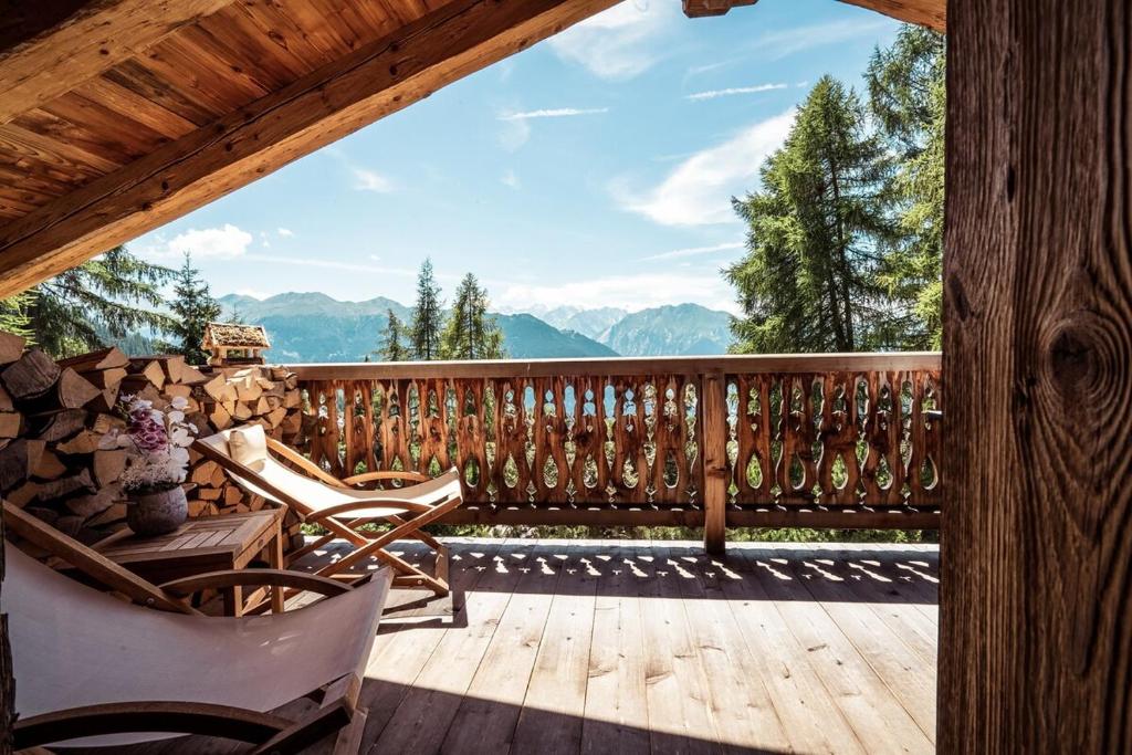a wooden deck with chairs and a view of mountains at Chalet with a beautiful view on the heights of in Verbier