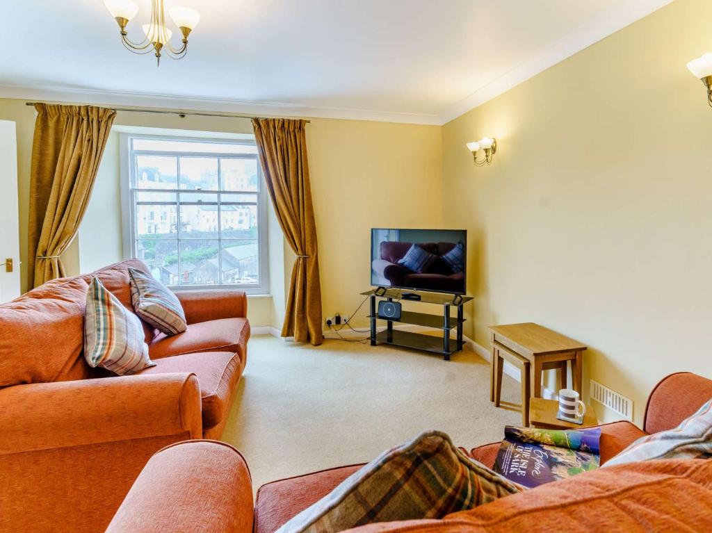 a living room with couches and a flat screen tv at 1 Bed in Tenby 83320 in Tenby