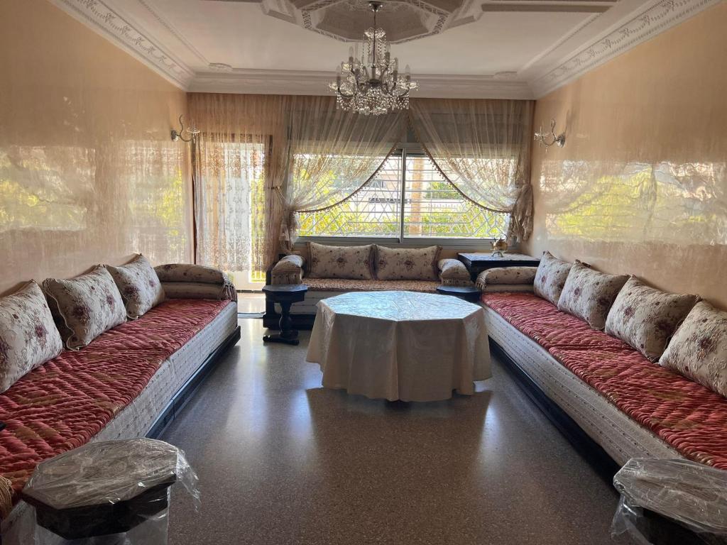una sala de estar con 2 sofás largos y una mesa en Beautiful 2-Bed Apartment in Rabat Hay Riad, en Kouas