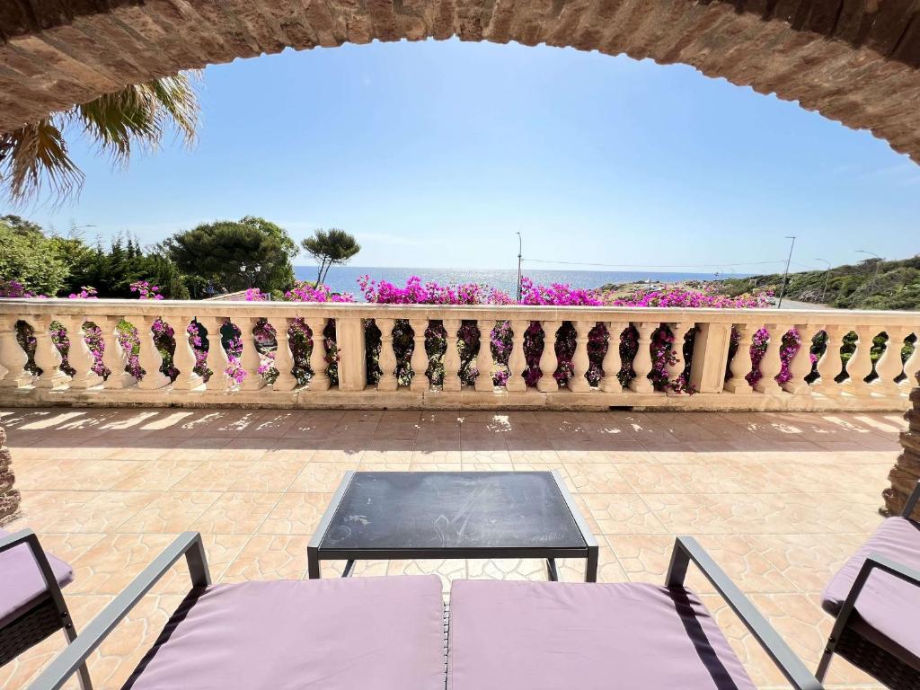 a patio with a table and a fence with pink flowers at Villa Les Issambres, 4 pièces, 7 personnes - FR-1-632-4 in Les Issambres