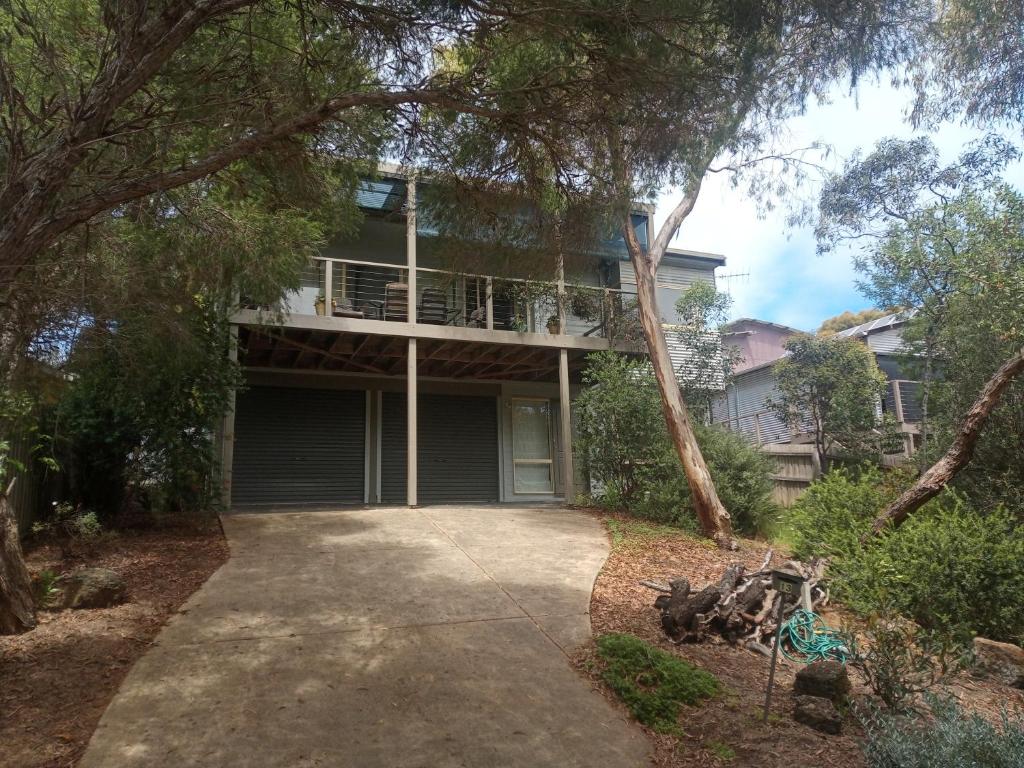 a house with a balcony and a driveway at Holiday house among native trees overlooking wetlands in Ocean Grove