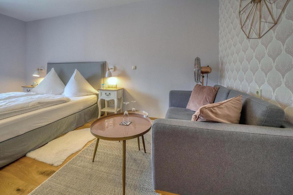 ein Wohnzimmer mit einem Bett, einem Sofa und einem Tisch in der Unterkunft Zentrale Ferienwohnung ROSEA nahe Kurpark in Bad Reichenhall