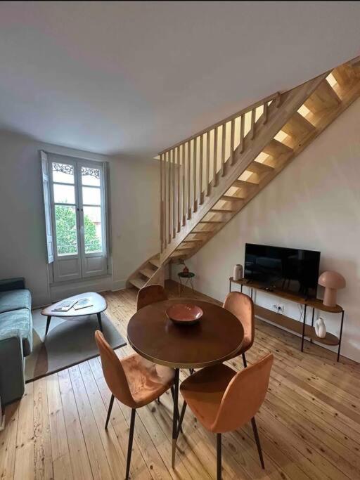 un salon avec une table et des chaises et un escalier dans l'établissement Lafourcade clim proche métro Palais de Justice, à Toulouse