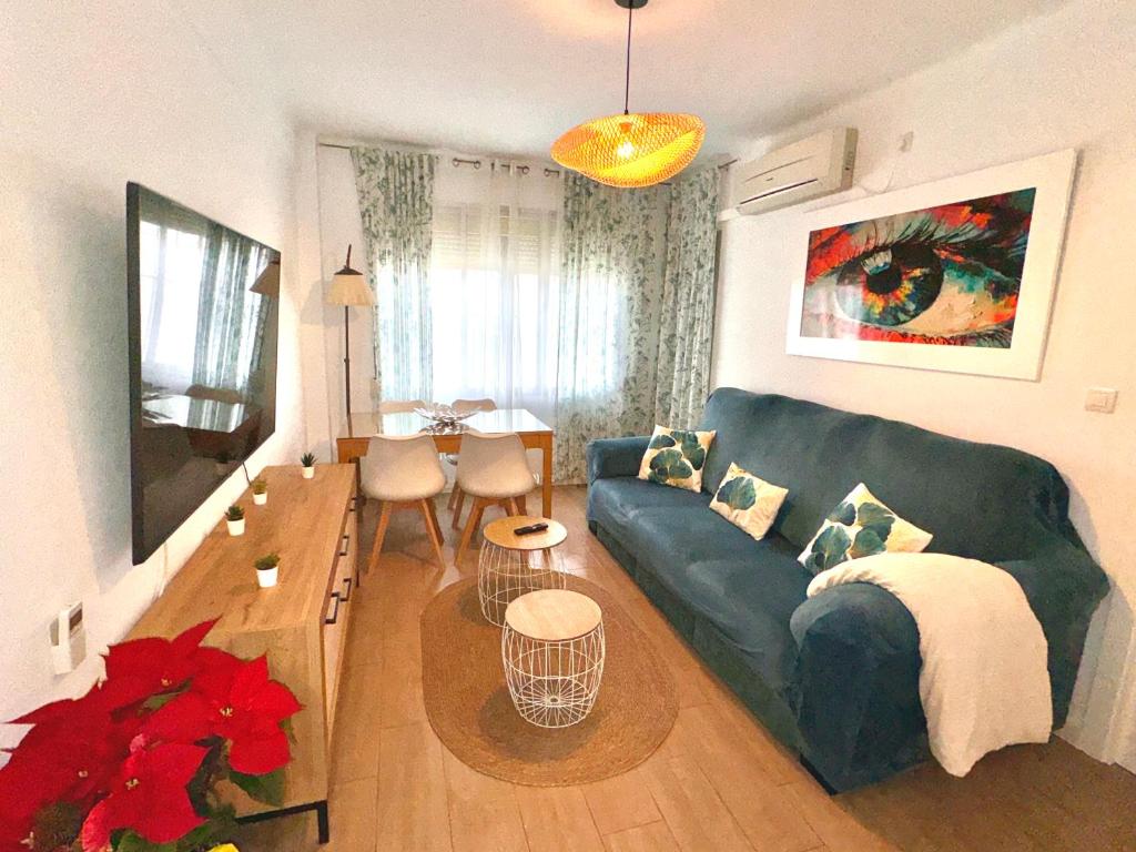 een woonkamer met een blauwe bank en een tafel bij Infantes Beach Apartment in Torre del Mar